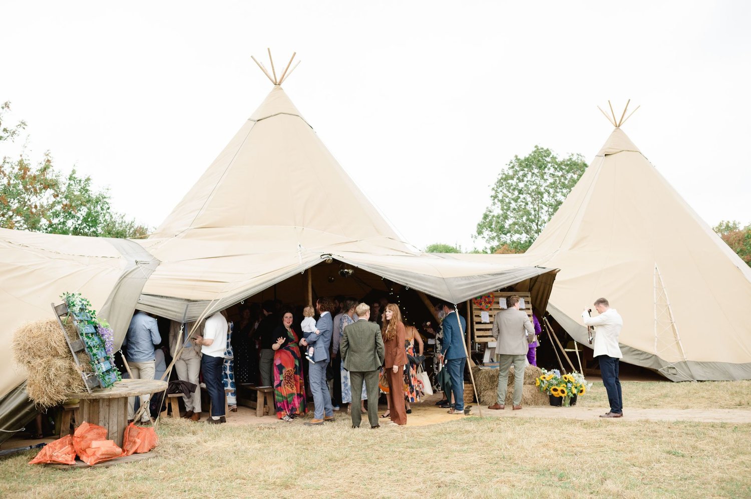 Guests gathering outside the wedding tipi at Ivy House Farm