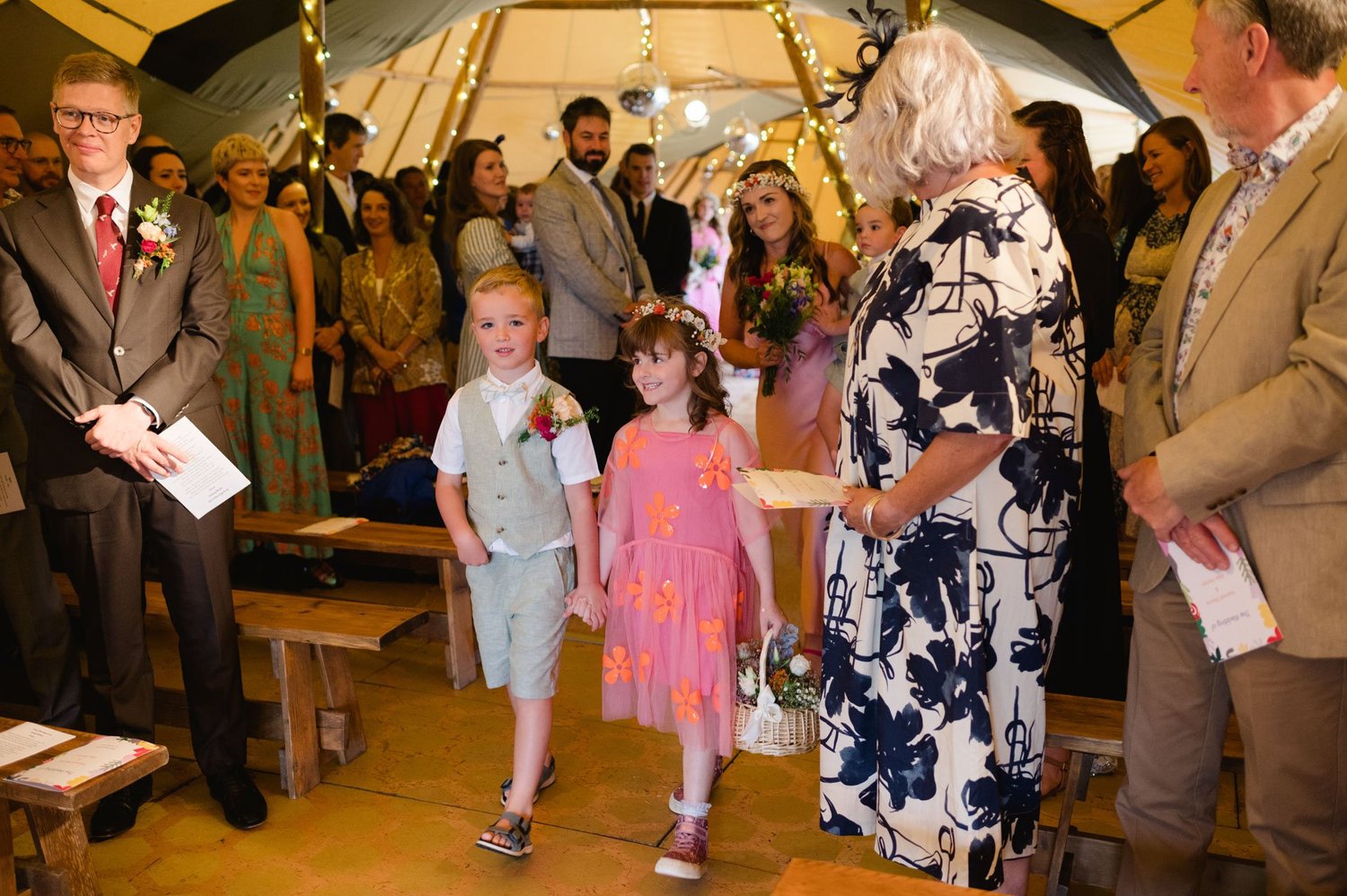 Two children walking down the aisle with ceremony booklets