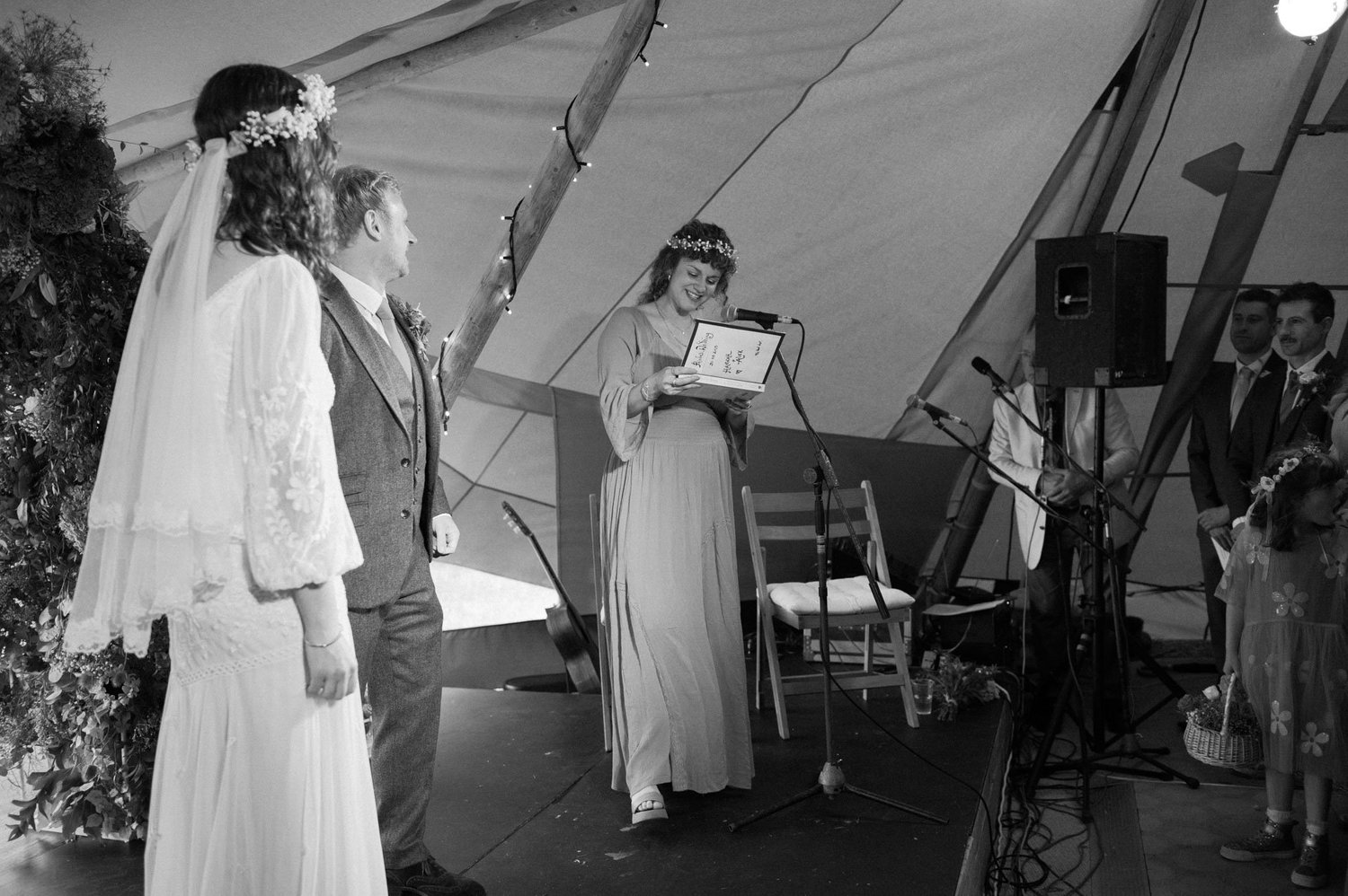 Hannah listening as a bridesmaid reads during the ceremony