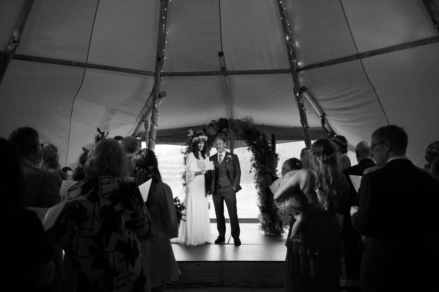 Guests watching Hannah and Alex exchange vows inside the tipi