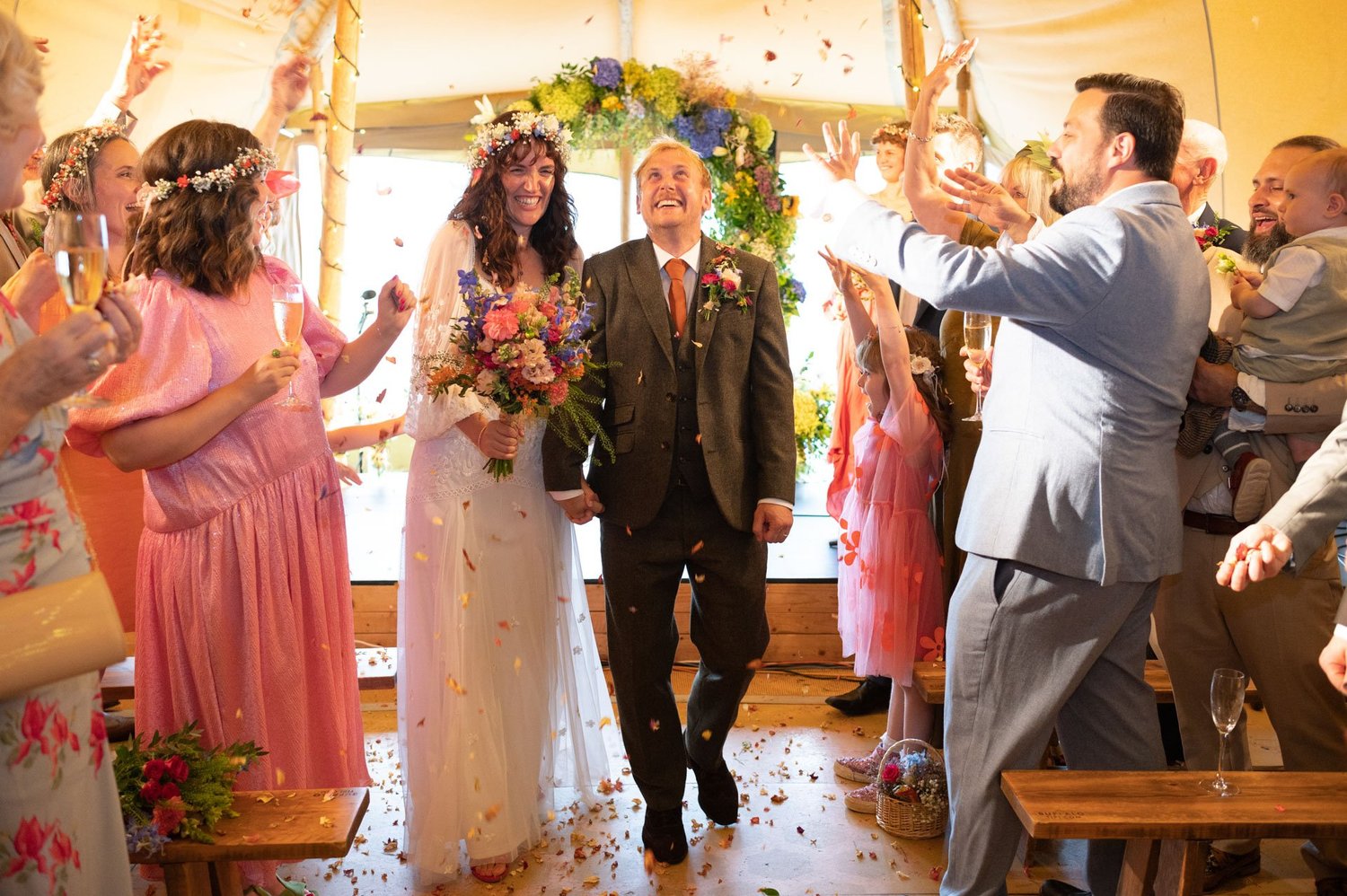 Hannah and Alex walking down the aisle through confetti