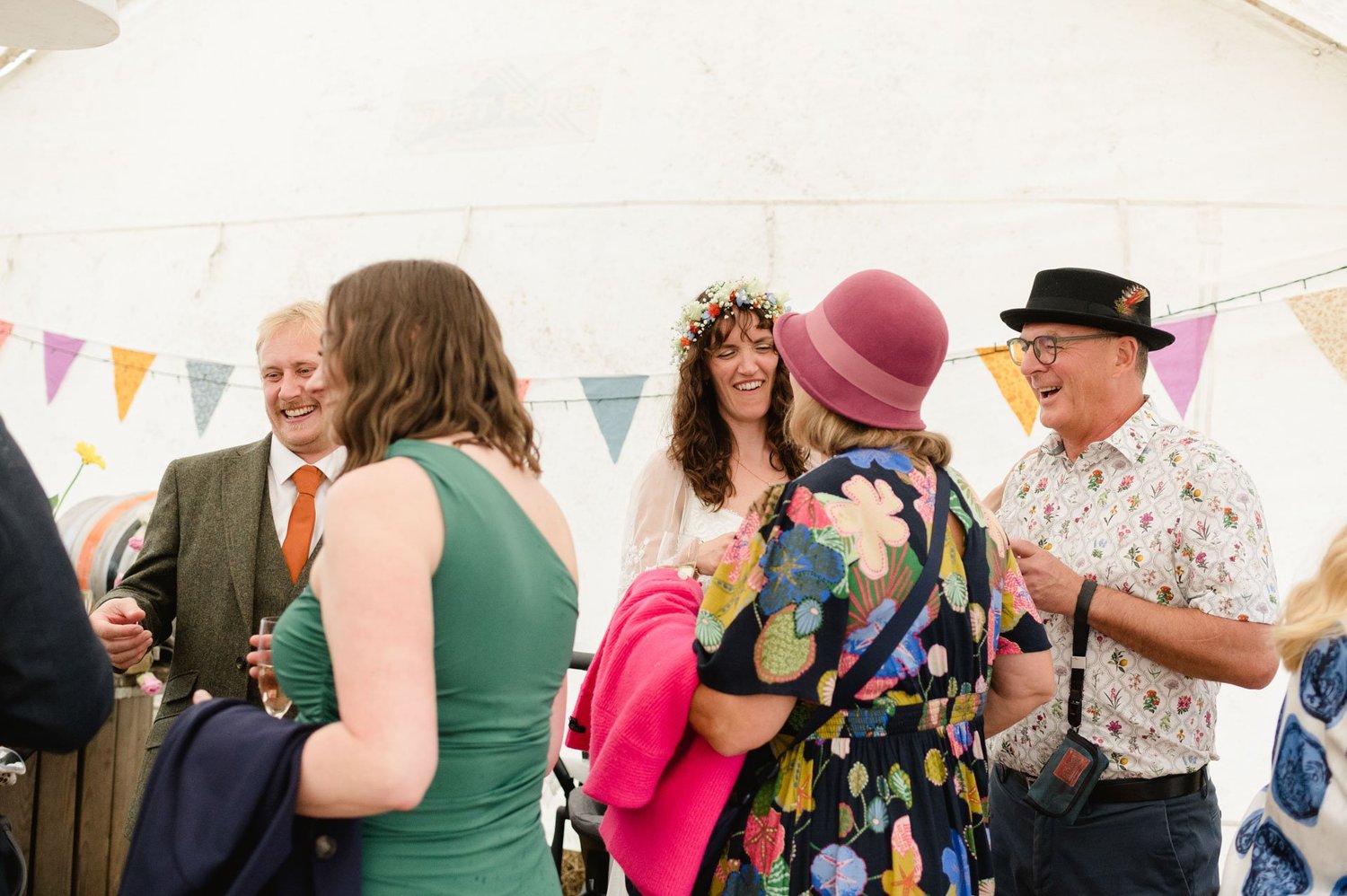Guests chatting under bunting at the farm reception