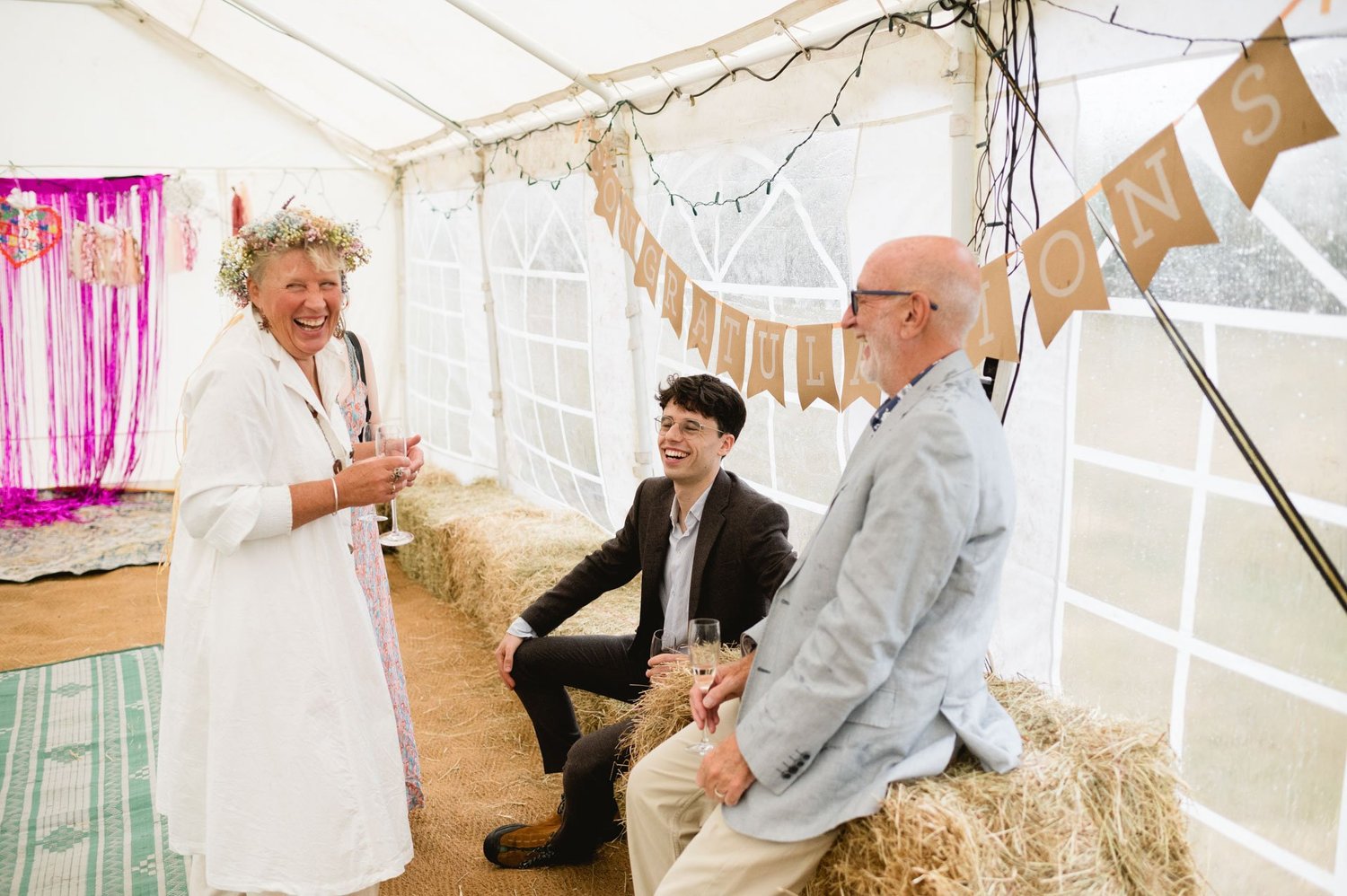 A guest speaking to seated family members inside the tipi
