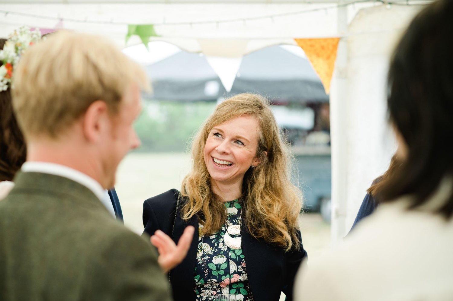 A smiling guest talking with Hannah and Alex outdoors