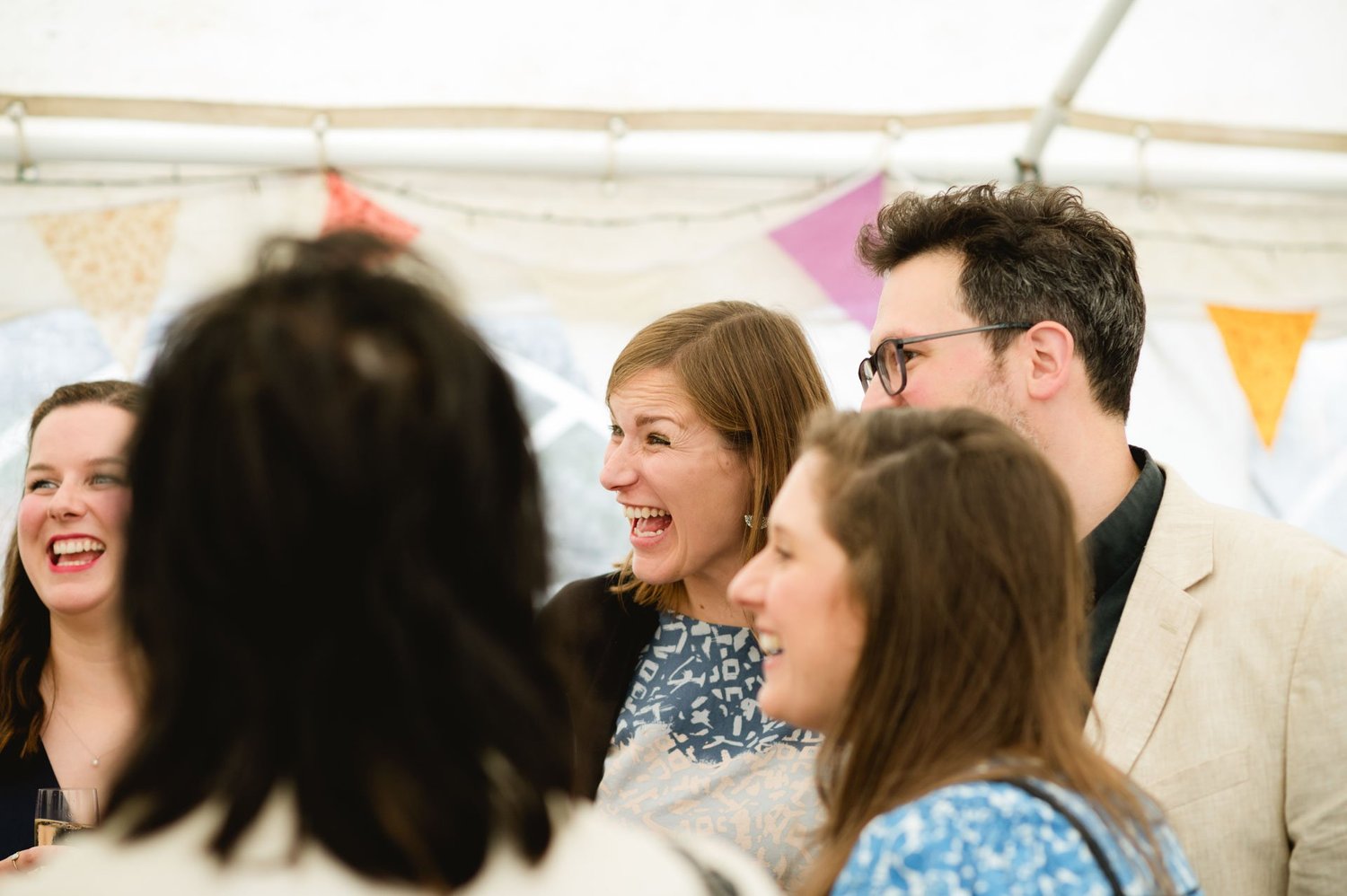 Wedding guests laughing together during the farm reception