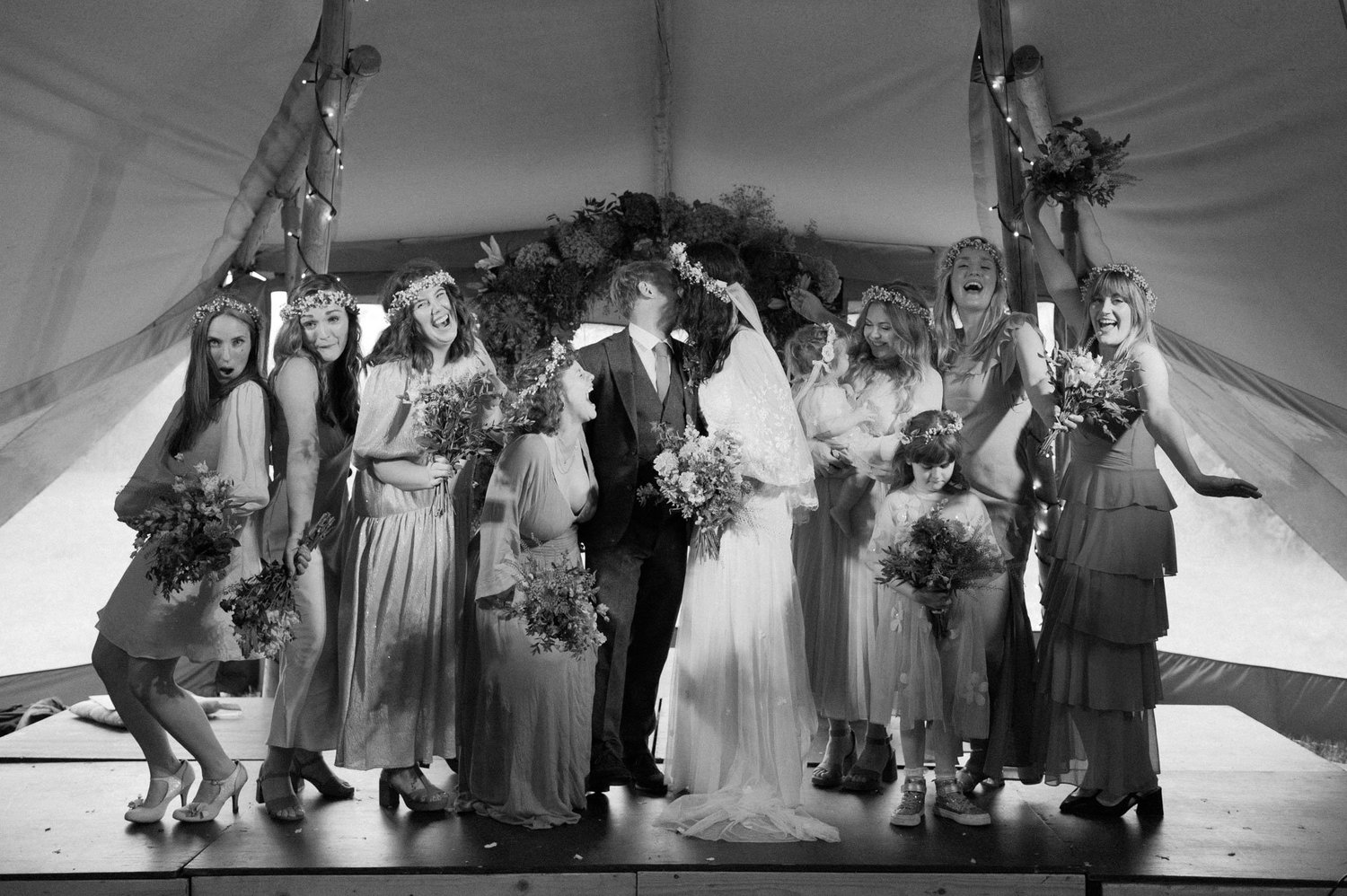 Hannah with bridesmaids and family posing on the tipi stage