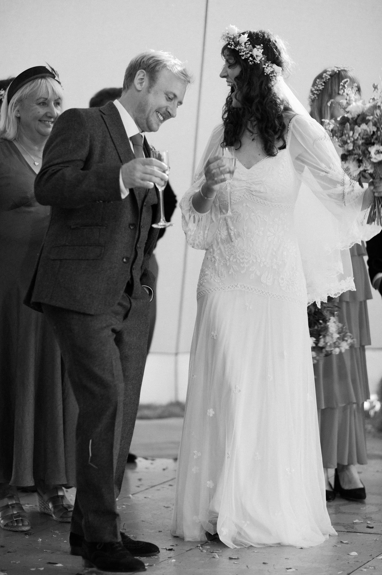 Alex raising a glass beside Hannah during the reception