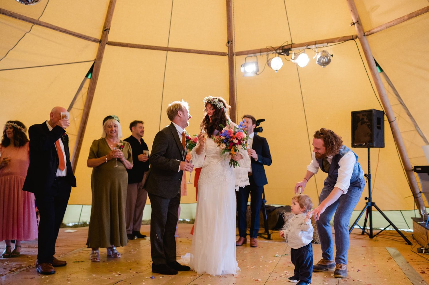 Hannah and Alex standing with family as a child walks forward