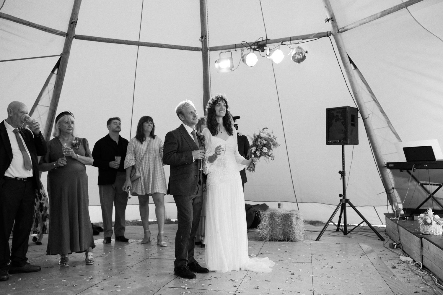 Hannah speaking to guests beside Alex during the wedding meal