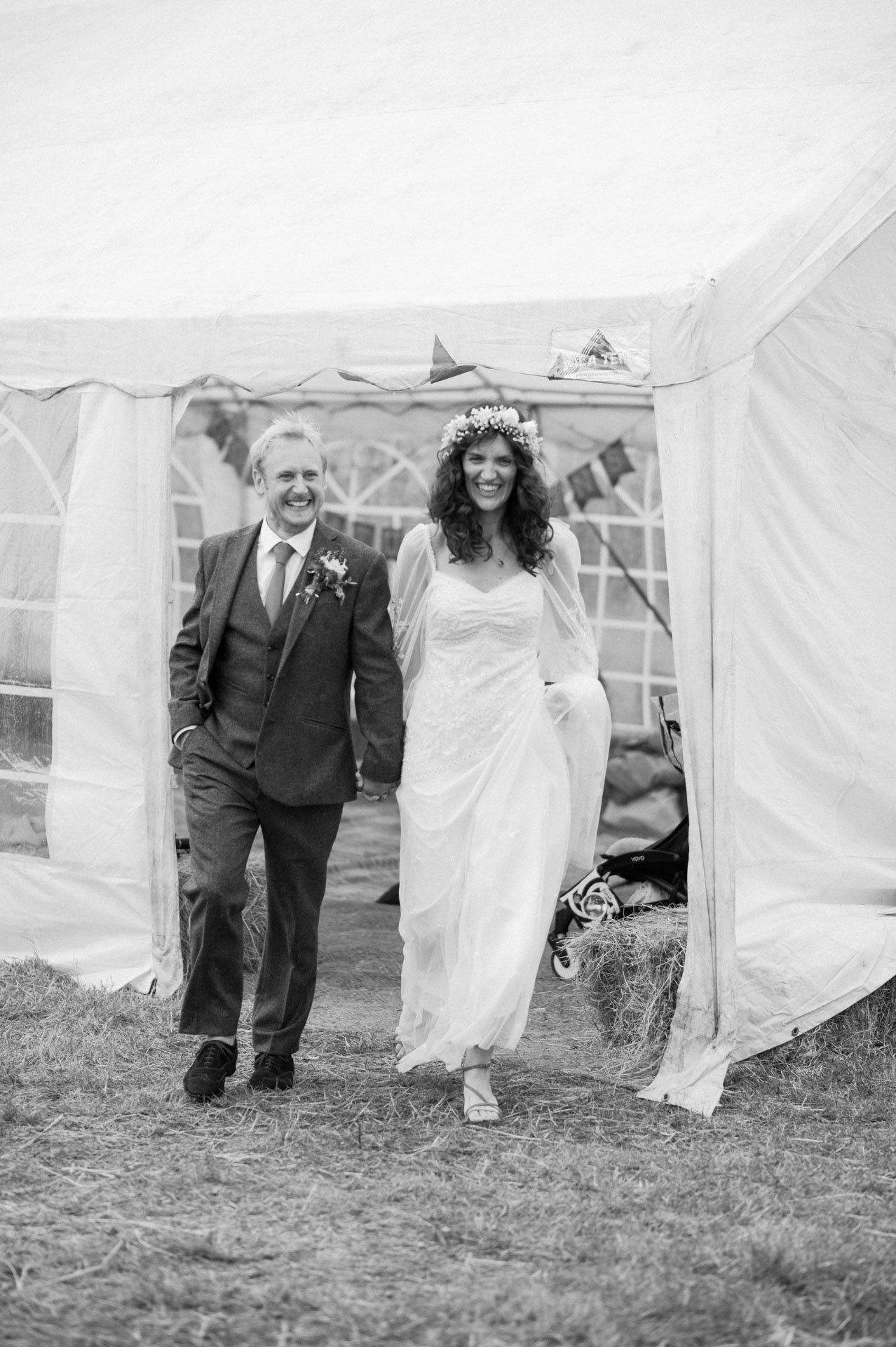 Hannah and Alex walking together outside the reception marquee