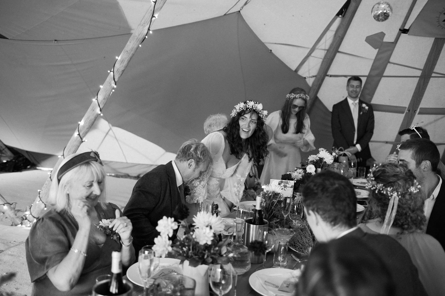 Hannah and Alex laughing with guests at the top table