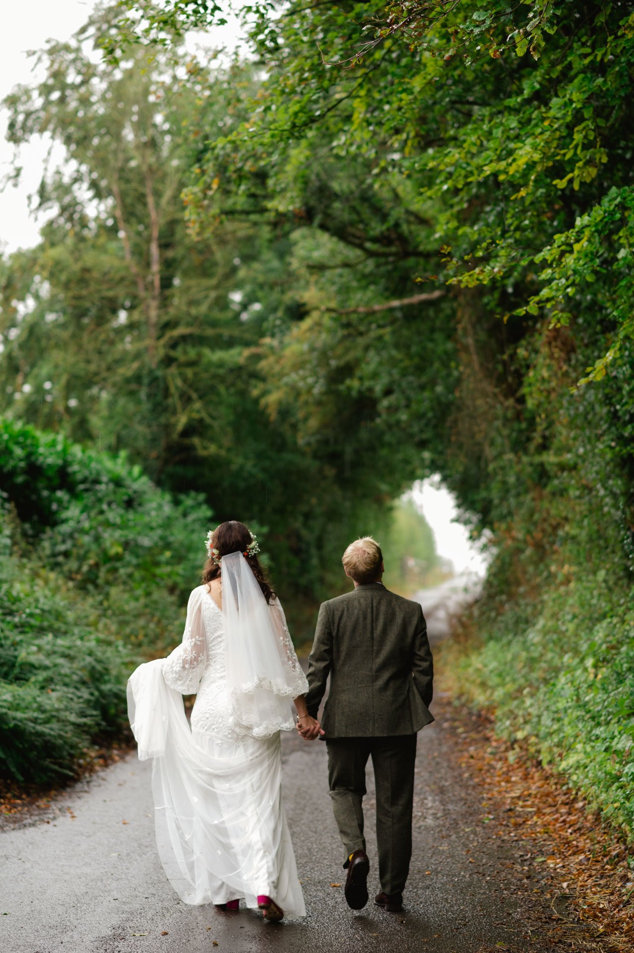 Hannah and Alex walking down a leafy lane after the rain