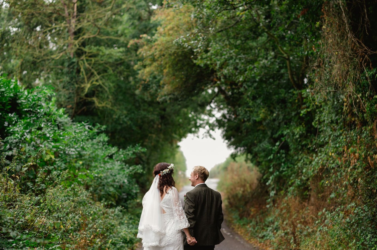 Hannah and Alex walking together beneath overhanging trees