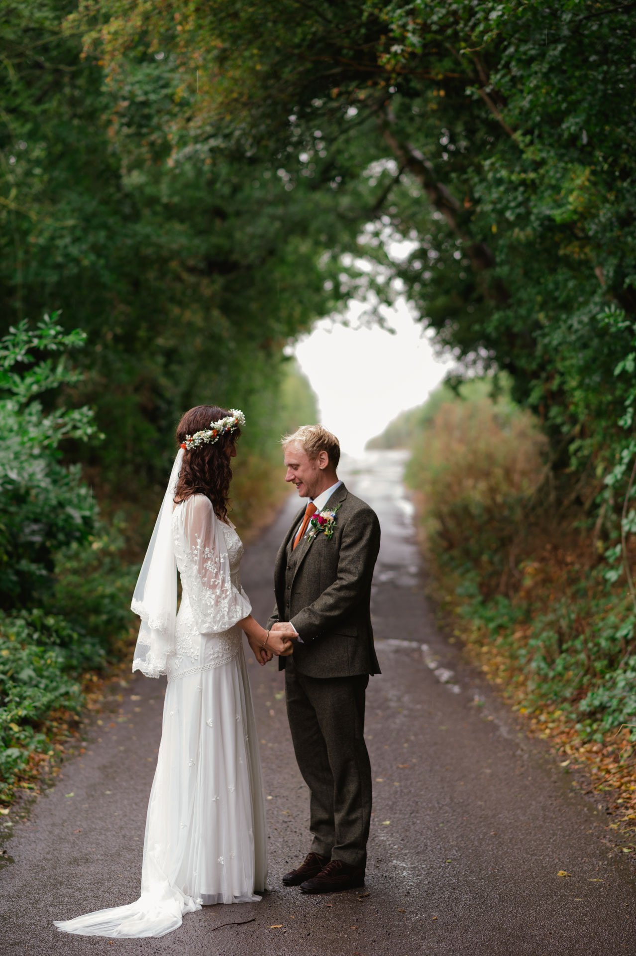 Hannah and Alex standing together on the tree-lined lane
