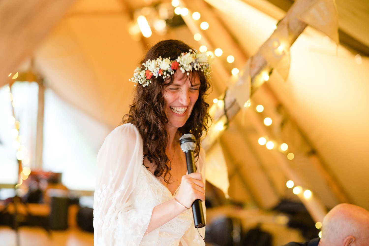 Hannah giving a speech under warm tipi lights