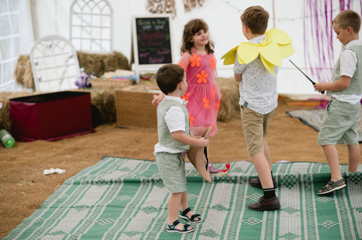 Children playing games on rugs inside the tipi