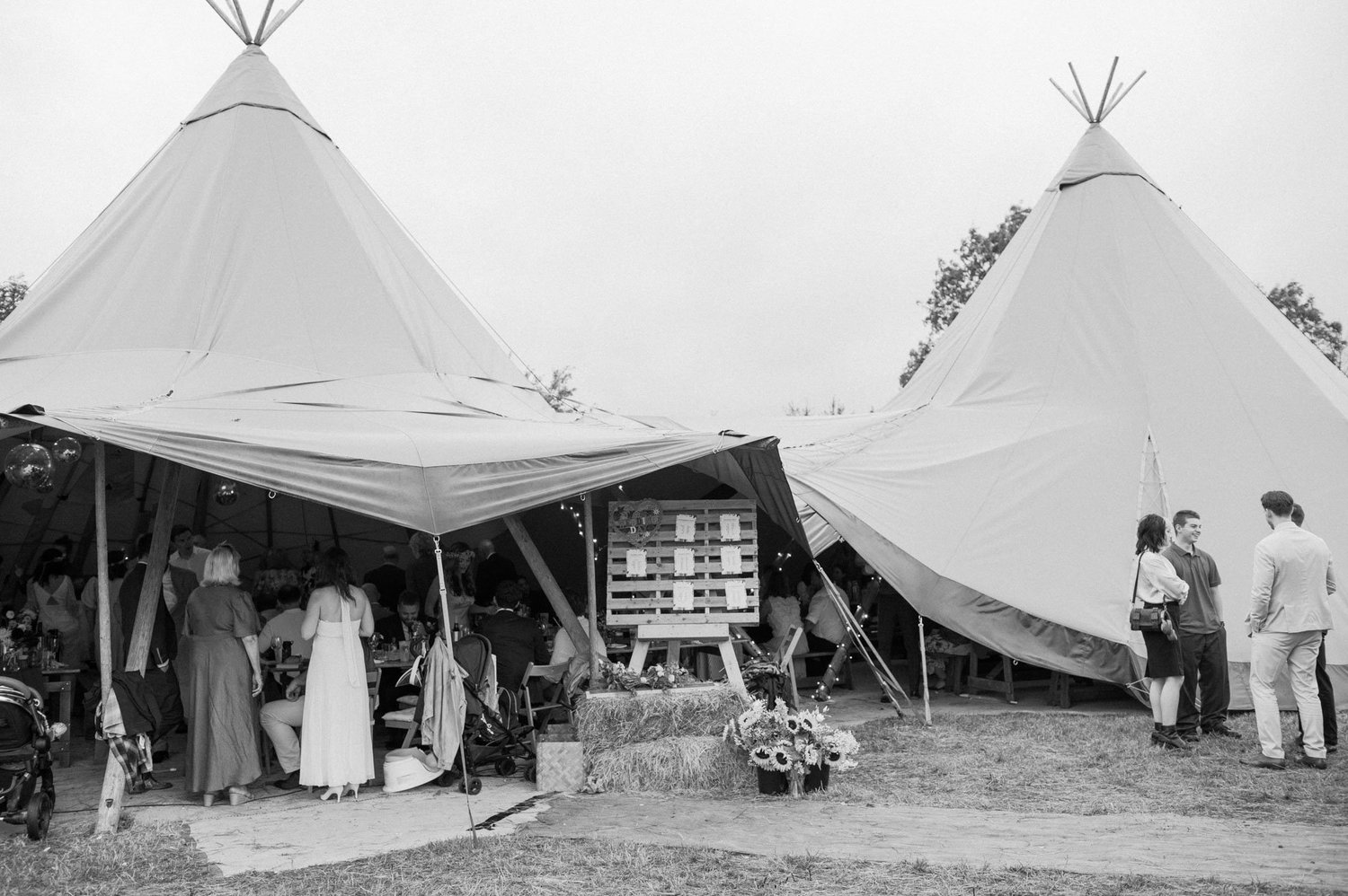 Guests mingling outside the tipis after the wedding meal
