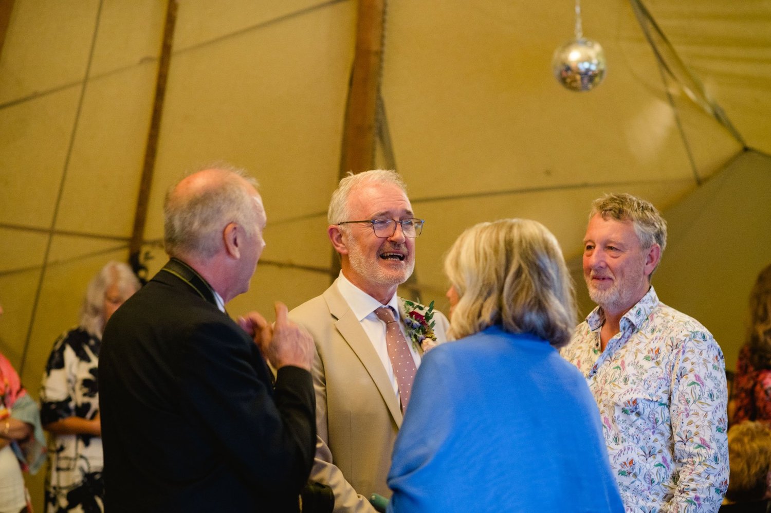 Wedding guests sharing a laugh during the evening reception
