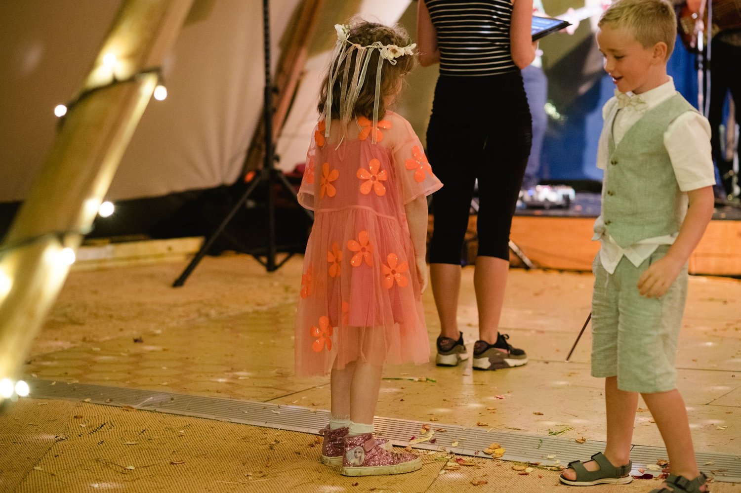 Children dancing on the wooden tipi floor in the evening