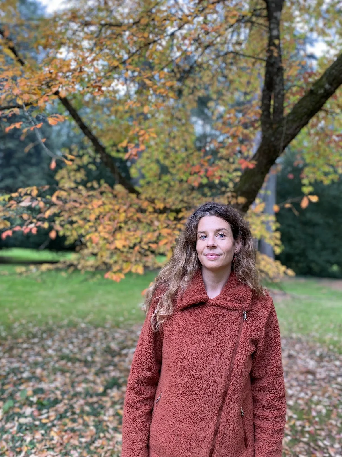 Lisa Dawn standing outdoors beneath autumn trees