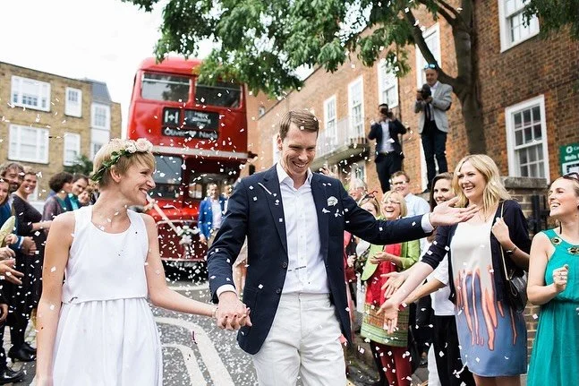 A wedding couple walking through confetti