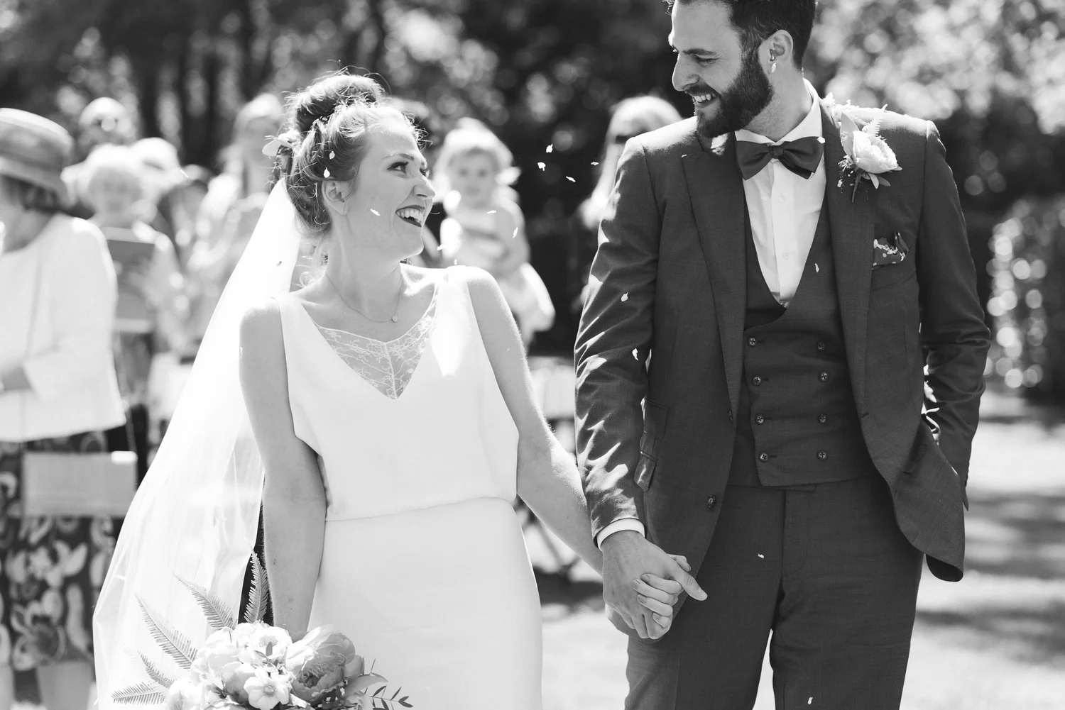 A happy bride and groom holding hands and walking outdoors during their wedding